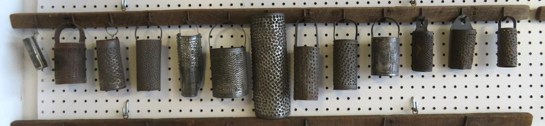 An artistic display of 13 handmade tin graters, late: An artistic display of 13 handmade tin graters, late 19th to early 20th century - all creatively mounted on a 19th century tobacco drying rack. The rack is 4'L and the utensils range in size from 3"L 