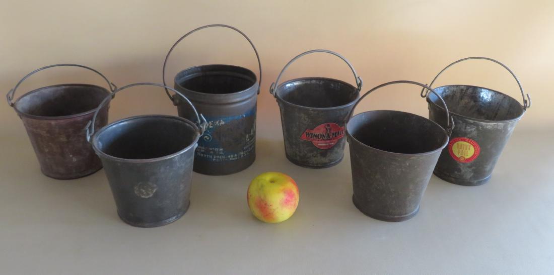 A grouping of 6 vintage tin dairy and lard buckets, one: A grouping of 6 vintage tin dairy and lard buckets, one signed Winona-Maid, all with bale handles in good condition. Early to mid 20th century. Ranging in size from 5:H to 6 1/4"H x 6 1/4"D. Provenanc
