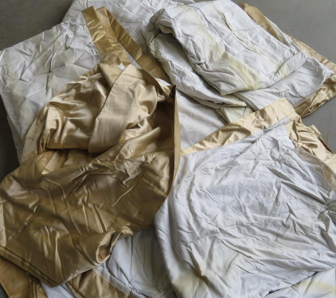 Three matched pairs of custom made lined draperies, in: Three matched pairs of custom made lined draperies, in gold silk fabric with white cotton backing. The backing with some soiling, the base of some panels with some spotted staining so curtains need pr