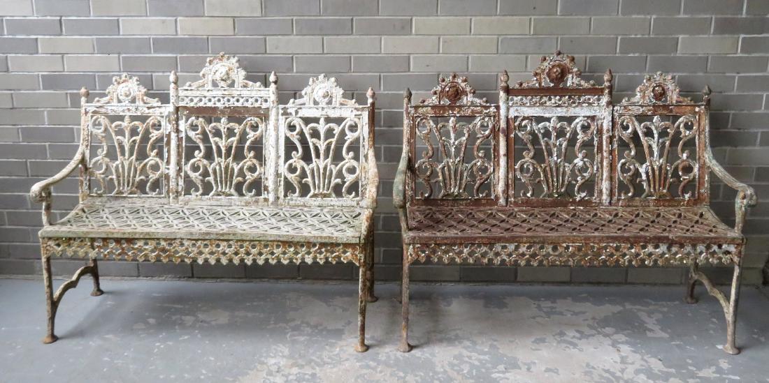 A pair of American classical cast iron garden benches: A pair of American classical cast iron garden benches having a triple paneled back, openwork seat with a so-called "curtain" apron, and scrolled arms. Late 19th century. 44 1/2" x 16"D x 36"H. Both in