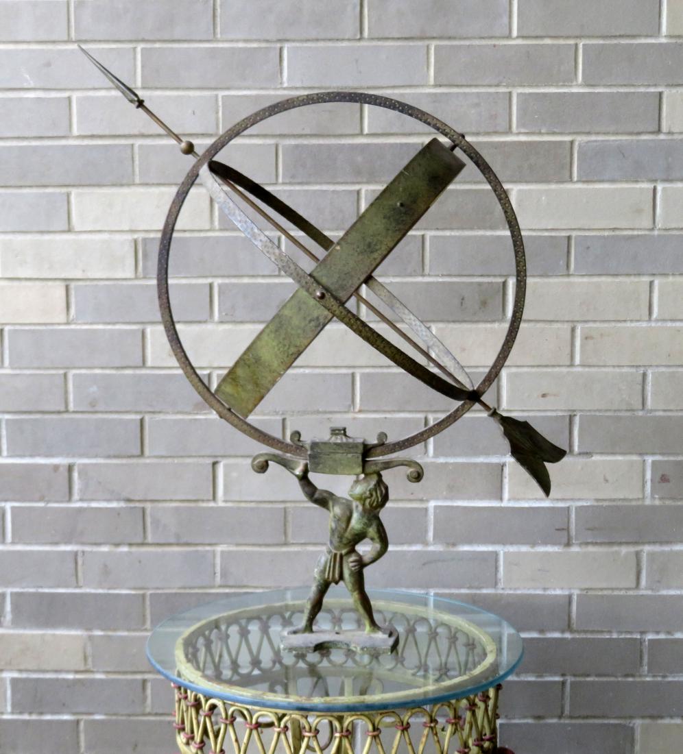 Cast iron armillary sphere depicting Atlas holding the: Cast iron armillary sphere depicting Atlas holding the world on his hand - faux bronze finish - circa 1930 - very good condition. 29 1/4"H x 31 1/4"L (length of arrow).Provenance: From the Samuel Phel