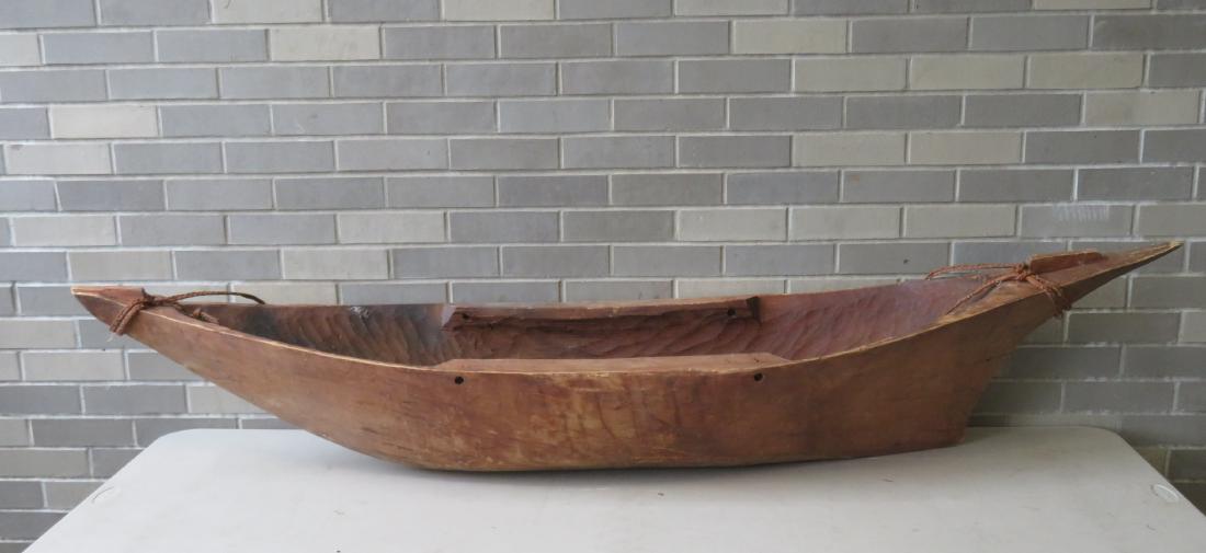 A primitive dugout canoe, probably for a child or used: A primitive dugout canoe, probably for a child or used as a pontoon, 19th century or later. Possibly from the Solomon Islands area. 75"L x 15"W x 15 1/2"H. Some use wear, a hole has been plugged in th