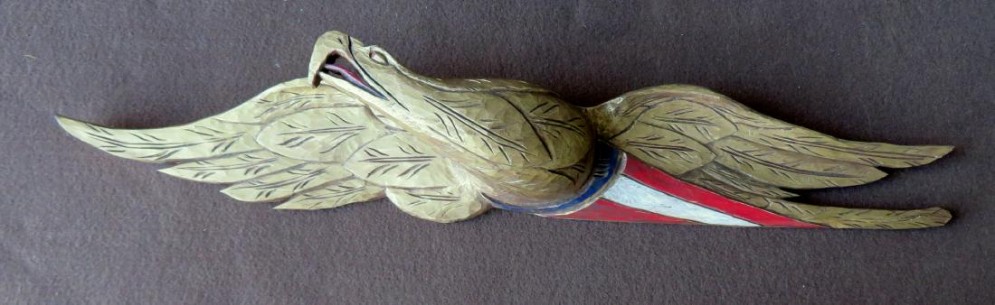 Carved wooden eagle wall plaque in original paint. The: Carved wooden eagle wall plaque in original paint. The eagle in gold above red, white and blue banner. Signed on reverse "Made in Woodstock CT" - maker's name illegible. Mid to later 20th century. Siz