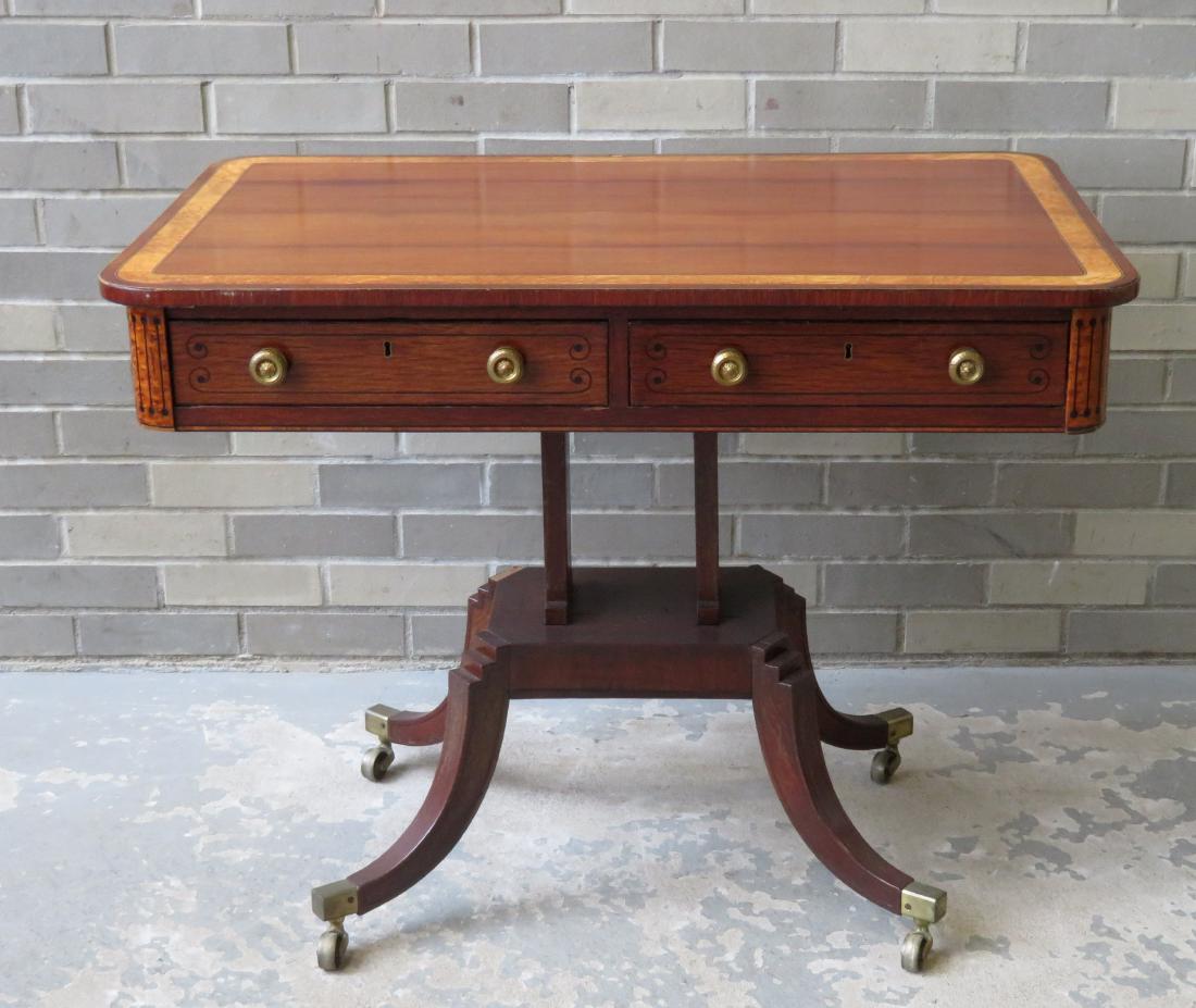Regency mahogany side table having a doubled banded: Regency mahogany side table having a doubled banded inlay of birdseye maple and mahogany on top over 2 rosewood drawers with ebony wood line inlays, on a 4 curved legs leading to brass casters. The to