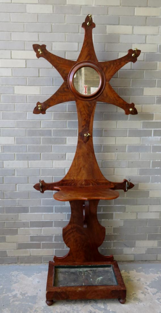 A walnut & mahogany 19th century hall tree. The top is: A walnut & mahogany 19th century hall tree. The top is star shaped with a central circular mirror, over a lower shelf over a tin lined rectangular plant holder at base. Two hat hooks are replacements,