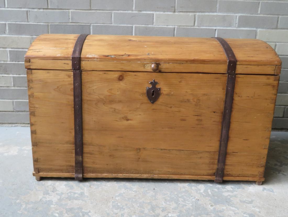 English scrubbed pine dome top trunk with hand forged: English scrubbed pine dome top trunk with hand forged iron straps and iron handles, dovetailed construction, 19th century. Very good condition. 34 1/2"W x 19 1/2"D x 22"H.