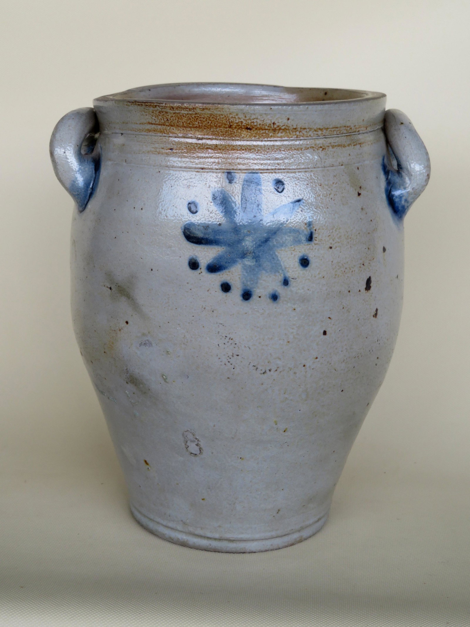 Stoneware jar decorated with a cobalt blue star on: Stoneware jar decorated with a cobalt blue star on front and back, open loop ears with brushed cobalt blue, small tight spider hairline on side otherwise very good condition. Early 19th century. 11"H.