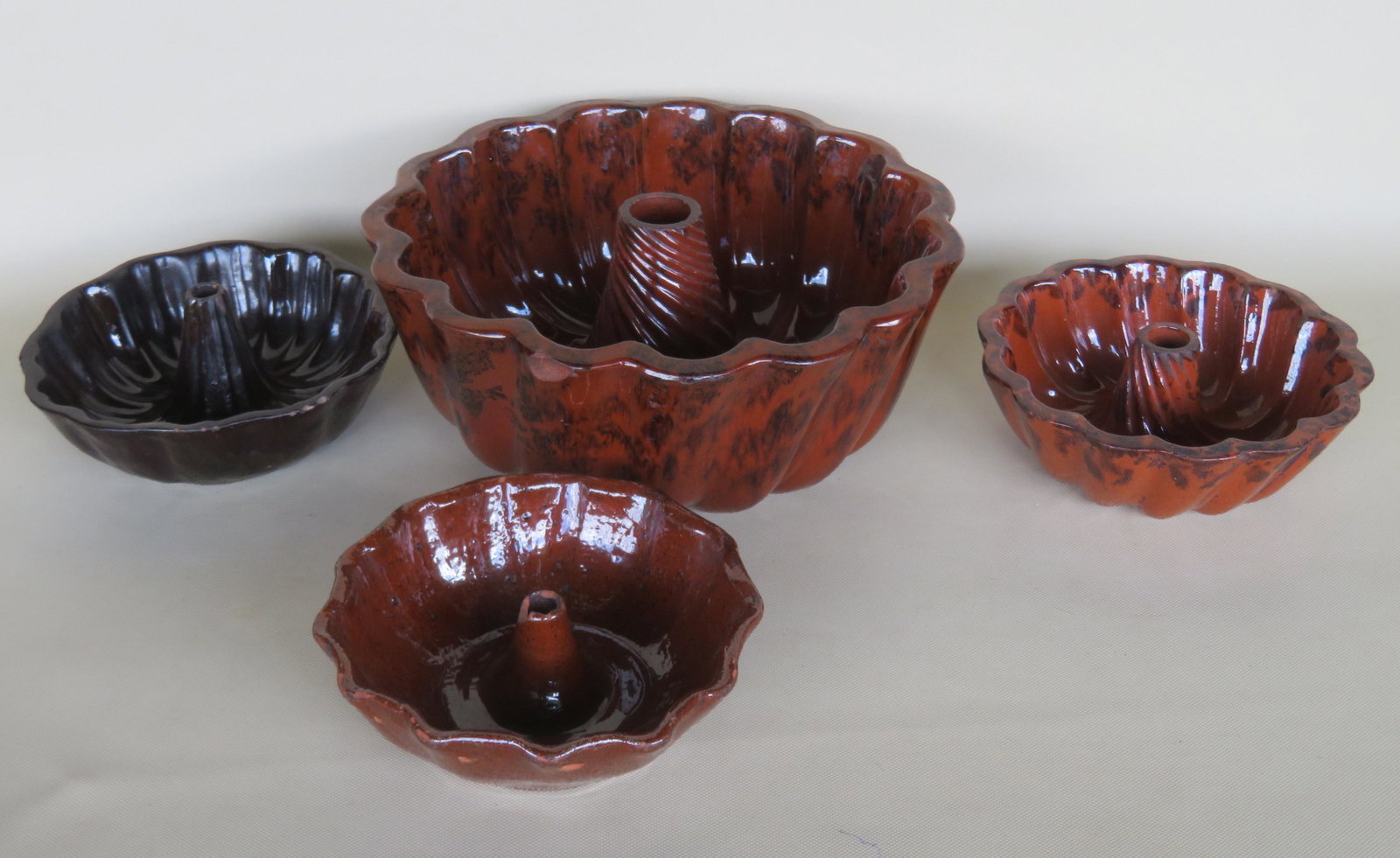 Grouping of 4 redware turk molds including the largest: Grouping of 4 redware turk molds including the largest with red glaze having manganese decorations (rim chip), a smaller red glaze mold with manganese decorations (very good condition), brown glaze (c