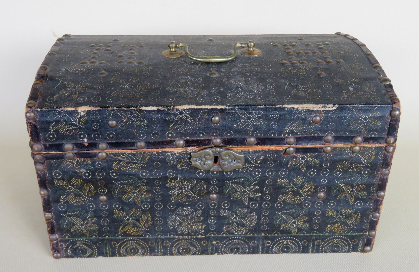 Small covered document box, with slight dome, and: Small covered document box, with slight dome, and profusely decorated with stamped designs of flowers and geometrics throughout - printed paper over canvas applied to box, similar to wall paper. The l