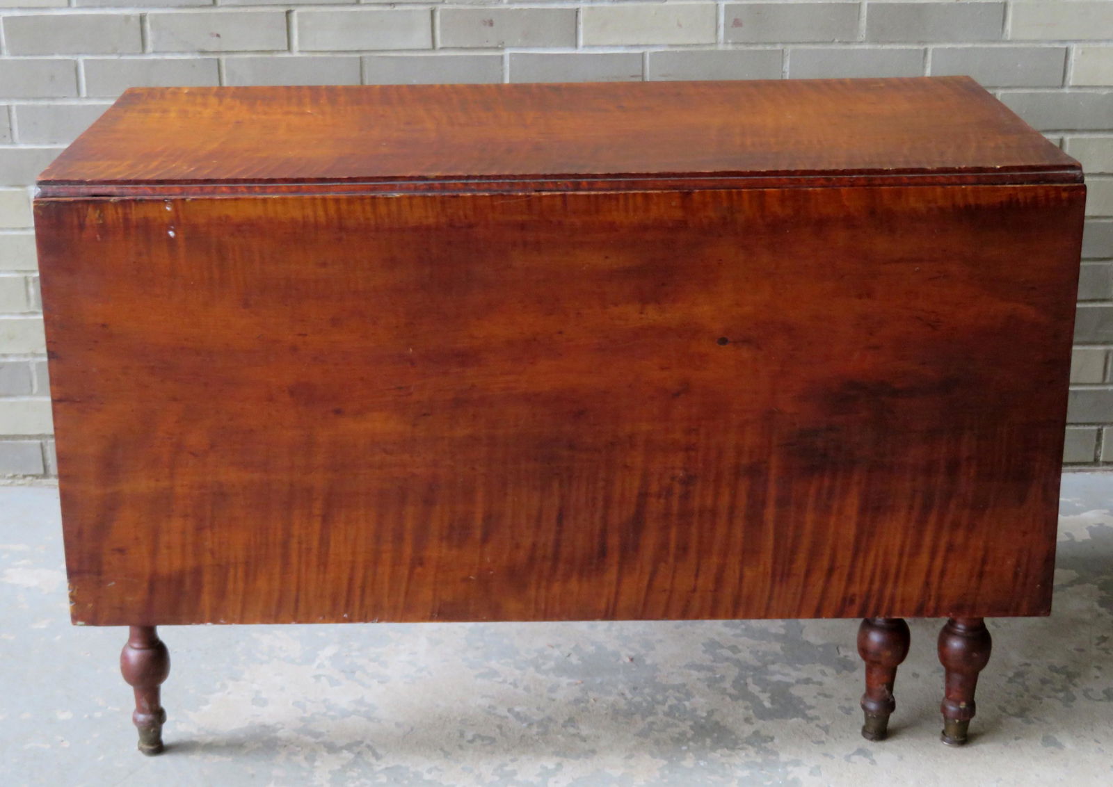 Sheraton tiger maple swing-leg drop leaf dining room: Sheraton tiger maple swing-leg drop leaf dining room table. Size: 43 7/8"L x 23 1/2"W (leaves down) & 60.5"W (leaves up). In old original surface and in very good condition. Circa 1820. Note while it