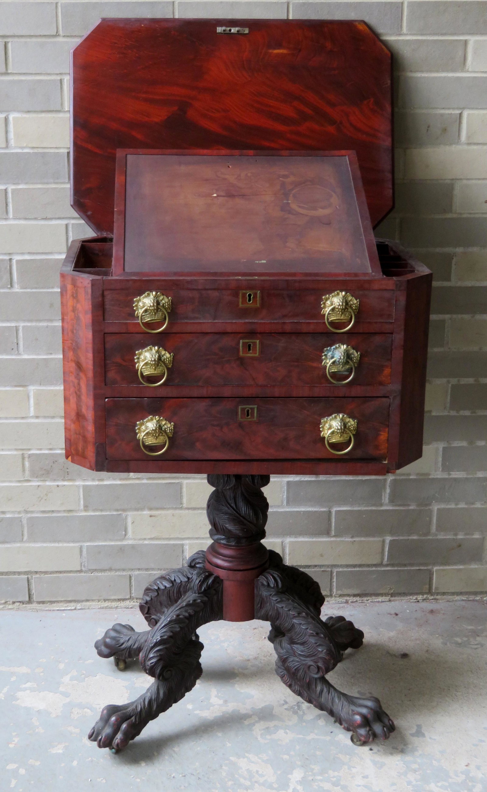 An outstanding early Empire octagonal shaped work table: An outstanding early Empire octagonal shaped work table on a heavily carved hairy paw foot base. The top with banded border, has a lift-top lid that exposes and adjustable interior writing surface wit