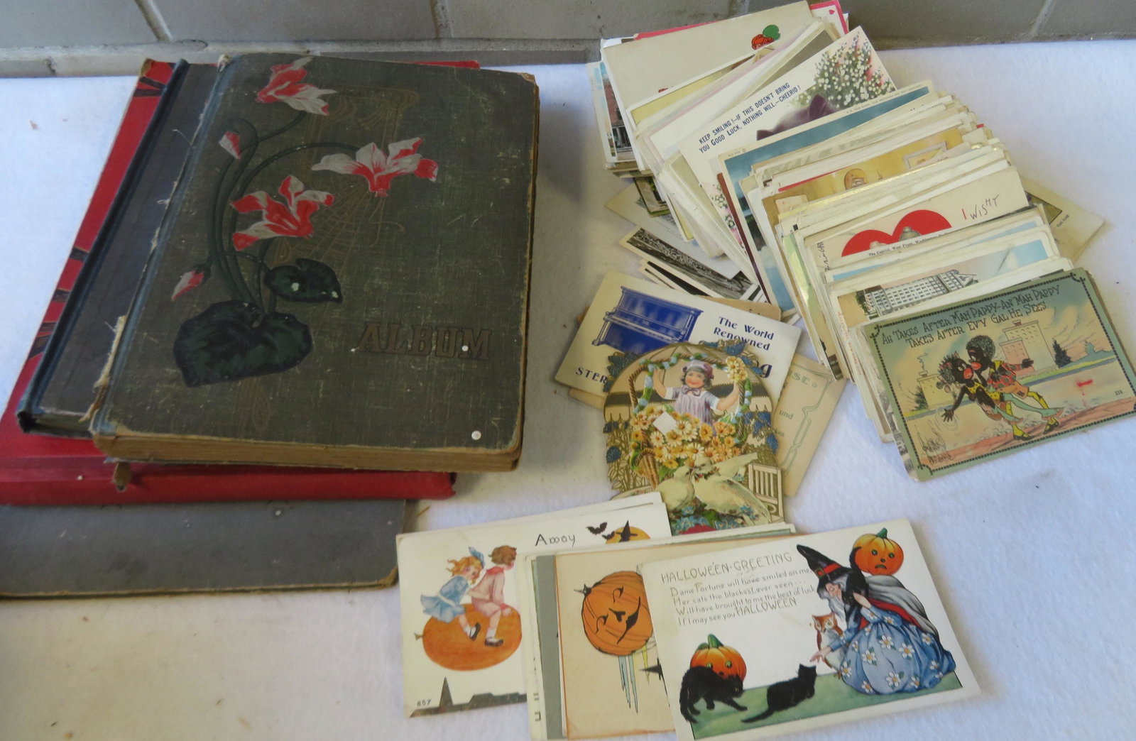 Grouping of approximately 140 loose postcards and 4: Grouping of approximately 140 loose postcards and 4 empty Victorian postcard albums (one with Christmas postcard of Santa Claus glued to the interior cover signed Ellen H. Clapsaddle. Other postcards 
