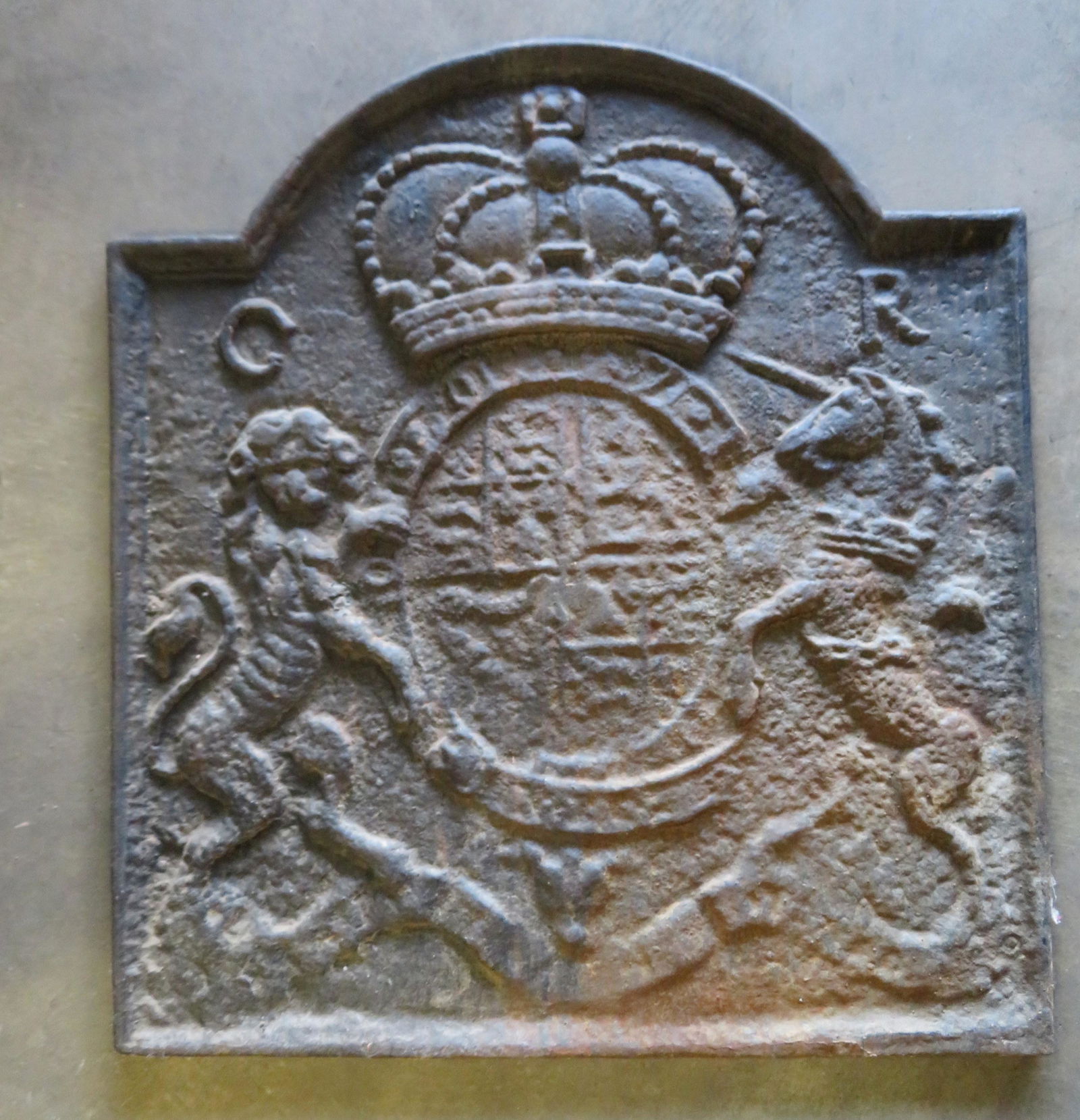 English style cast iron fireback having a crown flanked: English style cast iron fireback having a crown flanked by "G R" (Georgius Rex Imperator) over a central royal coat of arms which includes a standing lion and unicorn. Marked on reverse T. Elsley / VM