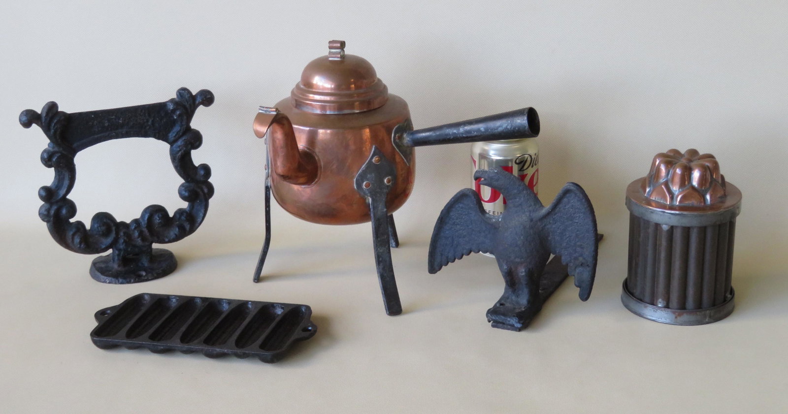 Grouping of 5 country items including: A small cast: Grouping of 5 country items including: A small cast iron corn bread mold - 8"L; a copper jelly mold with flower shaped lid - 5 1/4"H x 4"D; a cast iron eagle form snow bird; a cast iron boot scraper w