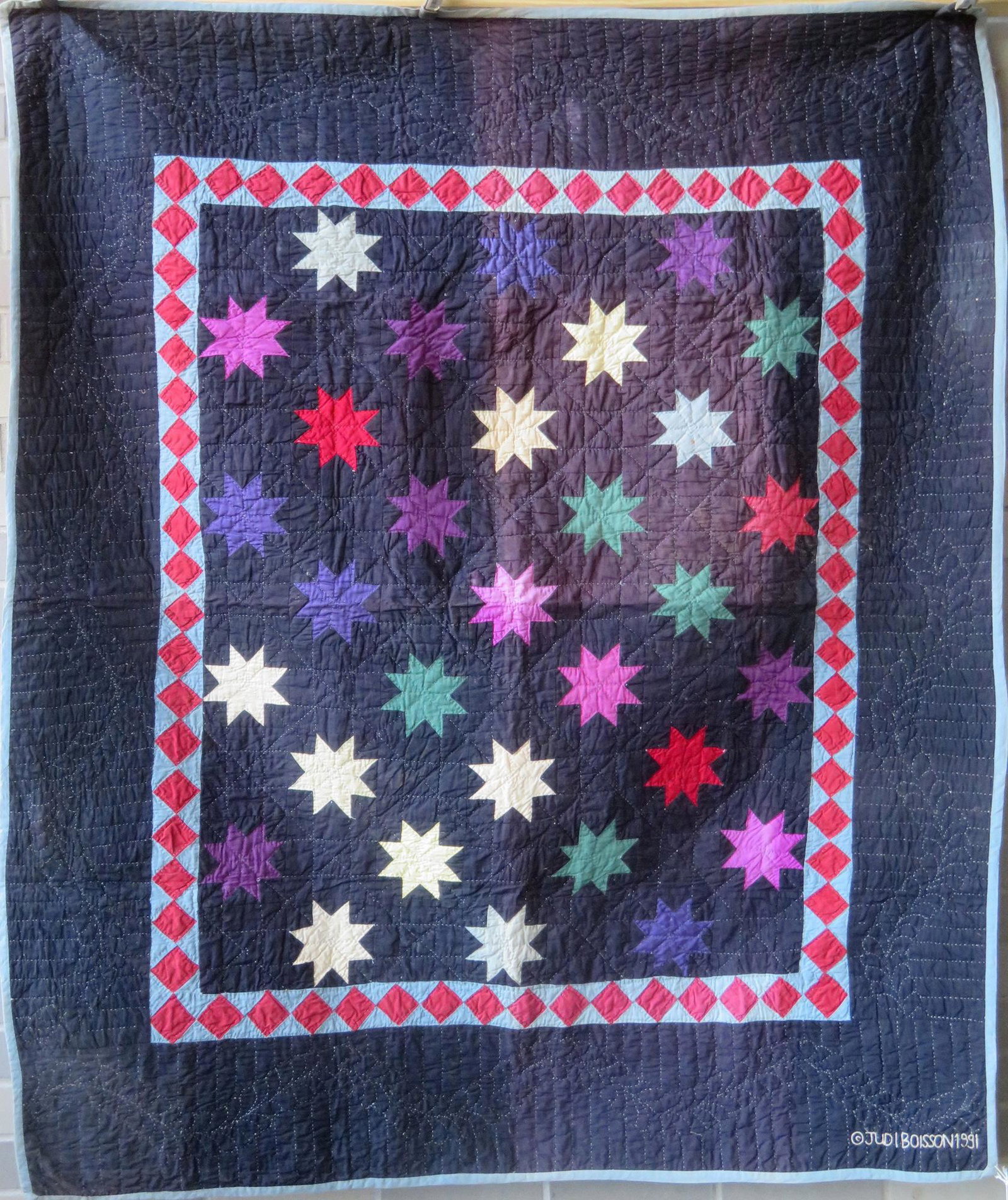 An Amish youth size hand sewn 20th century Amish quilt: An Amish youth size hand sewn 20th century Amish quilt with sewn signature "copyright Judi Boisson 1991" and label attached marked "Made Exclusively For Judi Boisson". 54 1/4" x 46 1/2". Visit her web