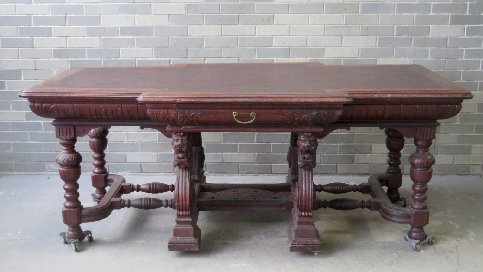 An ornate Victorian walnut partner's desk having a: An ornate Victorian walnut partner's desk having a shaped leather top with molded wooden border over a convex carved apron with acanthus leaf decoration. The desk with drawers on 4 ends of the table w