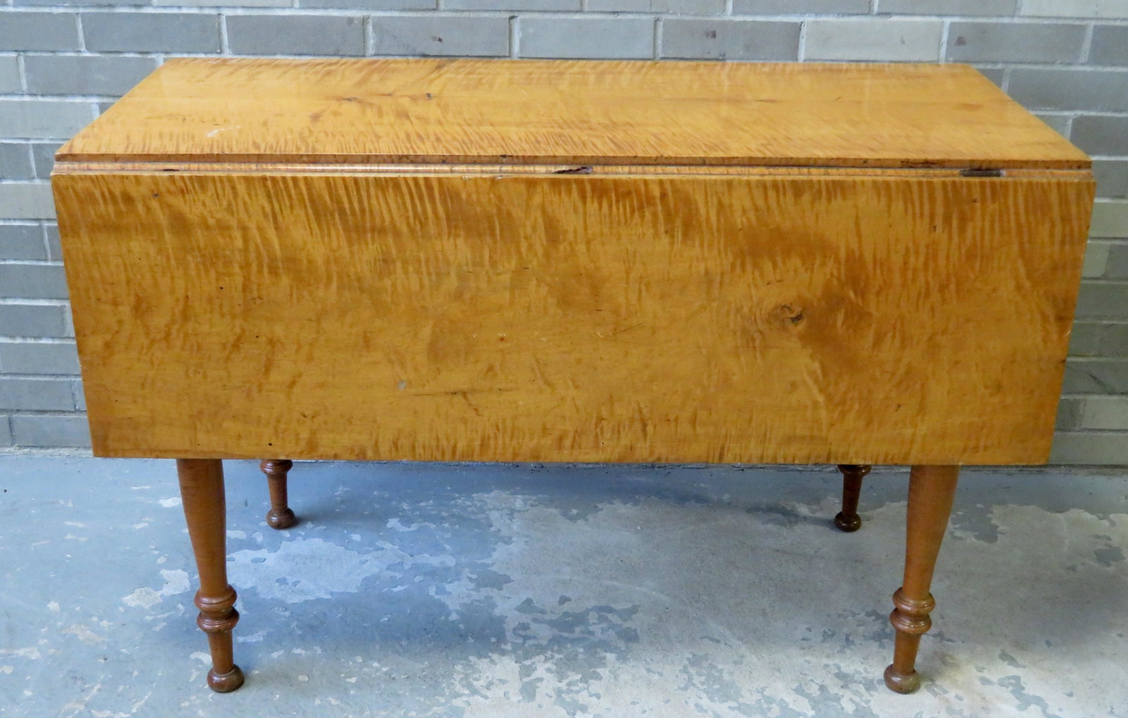 Sheraton tiger maple drop leaf table, circa 1820. Minor: Sheraton tiger maple drop leaf table, circa 1820. Minor losses to the rule joints that cover the hinges, otherwise very good refinished condition. Size with leaves down 43 1/2"L x 20 1/2"W x 28 1/2"H 