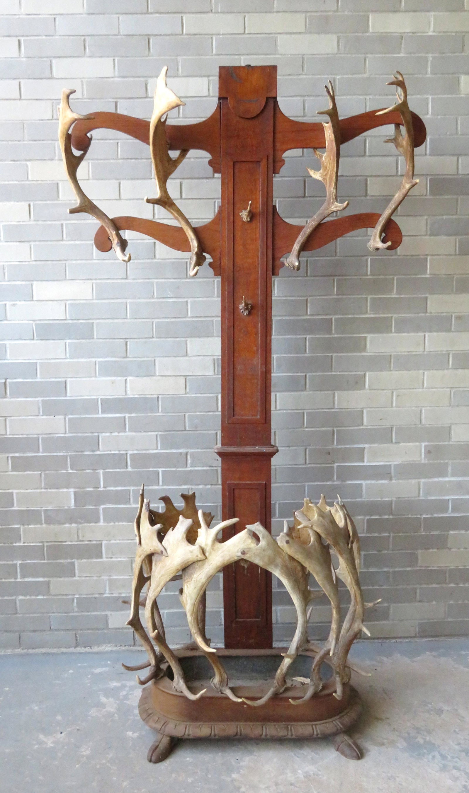 An exceptional rustic hall tree & umbrella stand: An exceptional rustic hall tree & umbrella stand decorated with English fallow deer horns on a wooden structure of pine and oak. Four scrolled arms extend from the top with the attached horns used as 