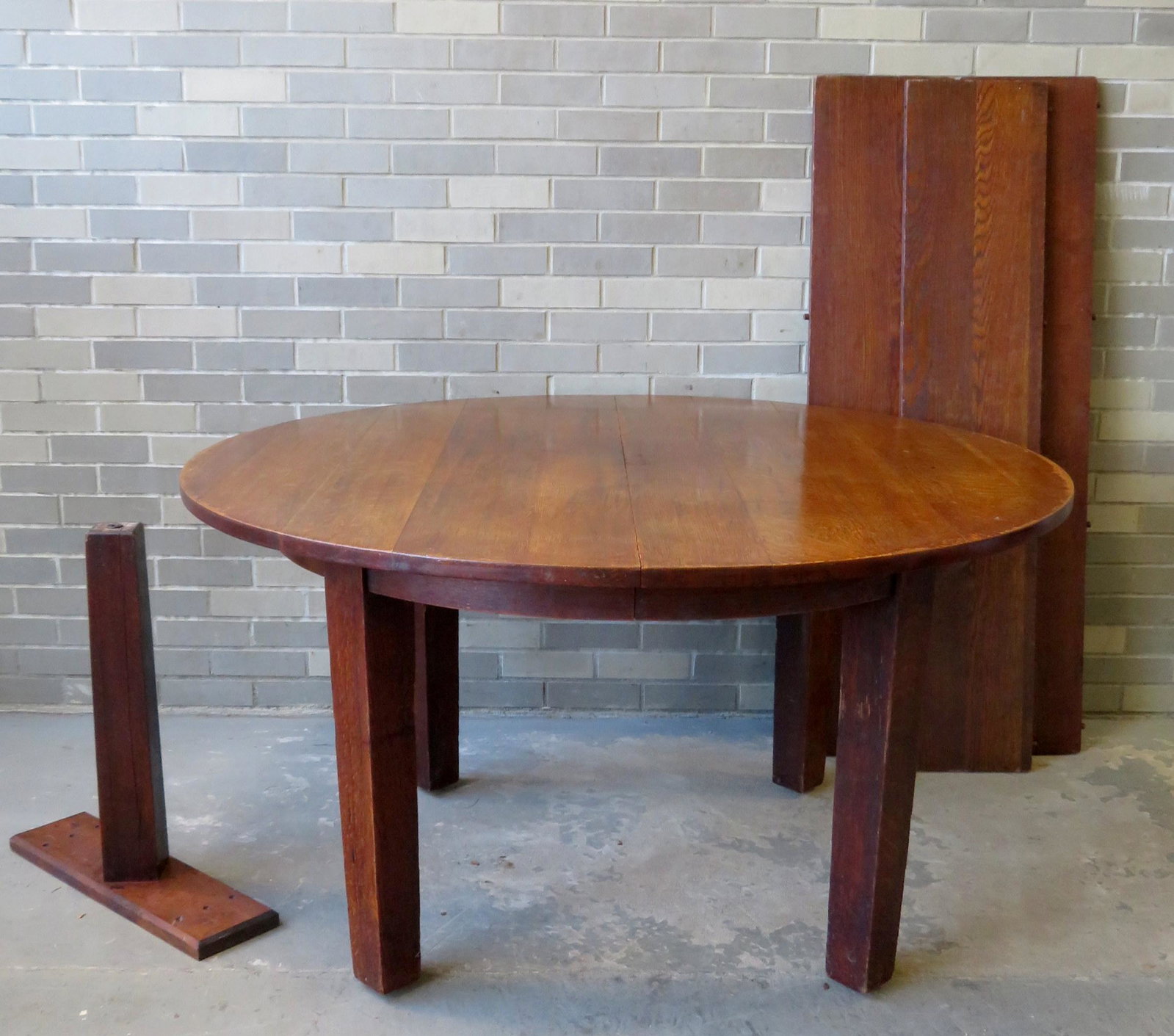 A signed Gustav Stickley round mission oak dining room: A signed Gustav Stickley round mission oak dining room with center leg and 3 leaves in original finish. Some use wear most noticeable around the edge of top, but overall very good condition. 54 1/4"D 