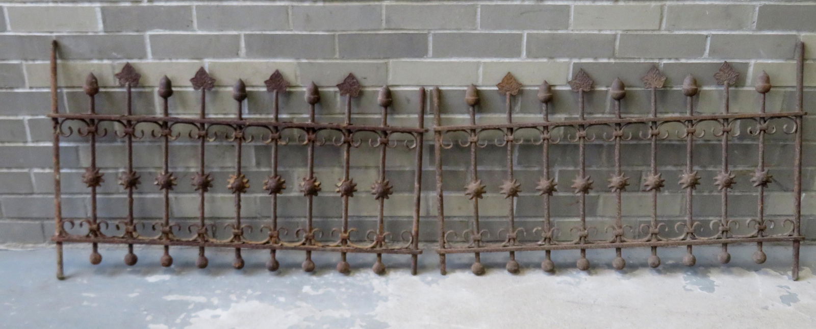 Matched pair of Victorian cast iron window grates,: Matched pair of Victorian cast iron window grates, decorated with leaf and acorn finials, 19th century, both in good condition. Each 34 1/2"L x 22 1/2"H.