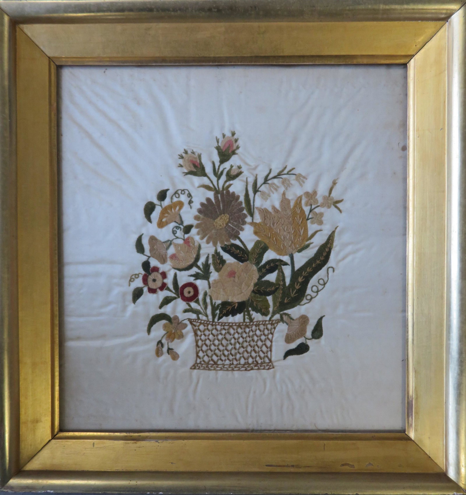 Framed silk embroidery depicting flowers in a basket,: Framed silk embroidery depicting flowers in a basket, late 18th to early 19th century. Some wrinkles in silk, otherwise very good condition. Displayed in a period early 19th century lemon gold frame. 