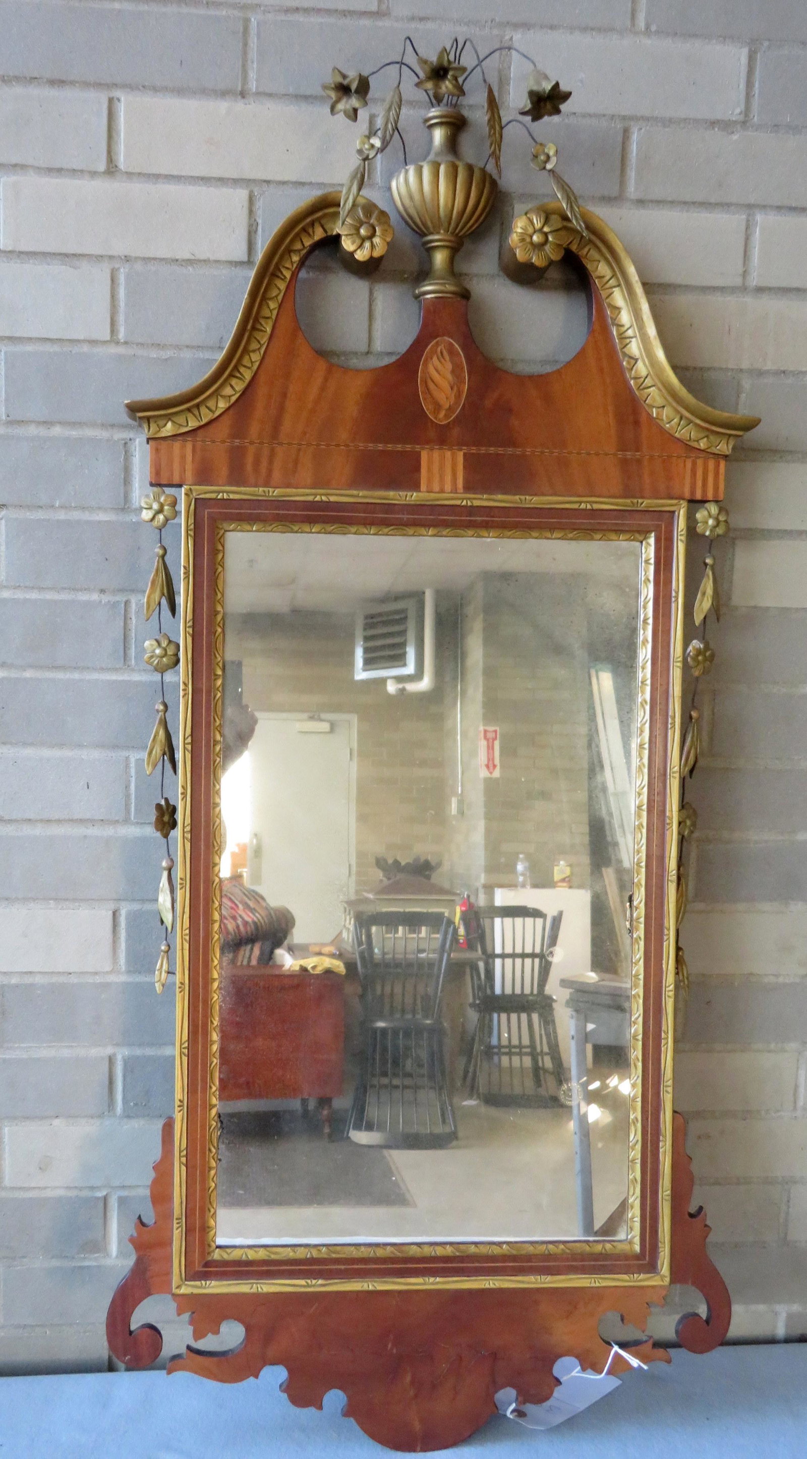 Hepplewhite style mahogany mirror with broken arch top: Hepplewhite style mahogany mirror with broken arch top with urn of flowers finial, carved rosettes in terminals of broken arch, conch shell inlay under urn, gesso attached to wire decorated with flowe