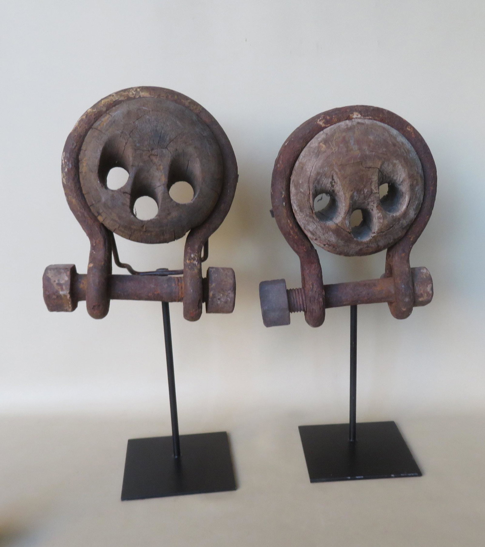 Two early deadeyes mounted on museum iron stands, both: Two early deadeyes mounted on museum iron stands, both in good condition, late 18th to early 19th century. 11"W x 12"H and 10 1/2"W x 12 1/2"H.