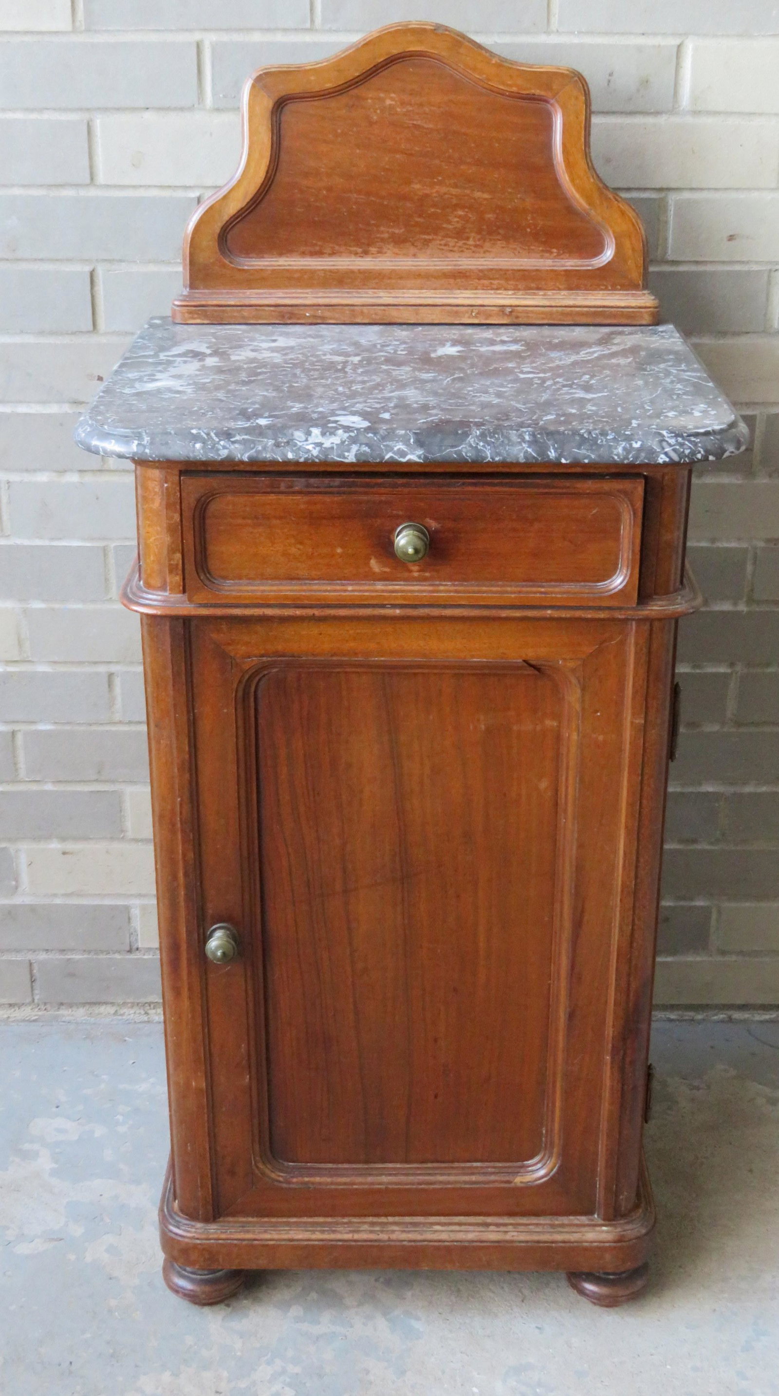 Victorian walnut commode having a gray marble top with: Victorian walnut commode having a gray marble top with molded edge, backsplash, 1 drawer over 1 paneled door and paneled sides, on bun feet. 15 3/4"W x 19 1/4"D x 41"H. Minor use wear and overall good