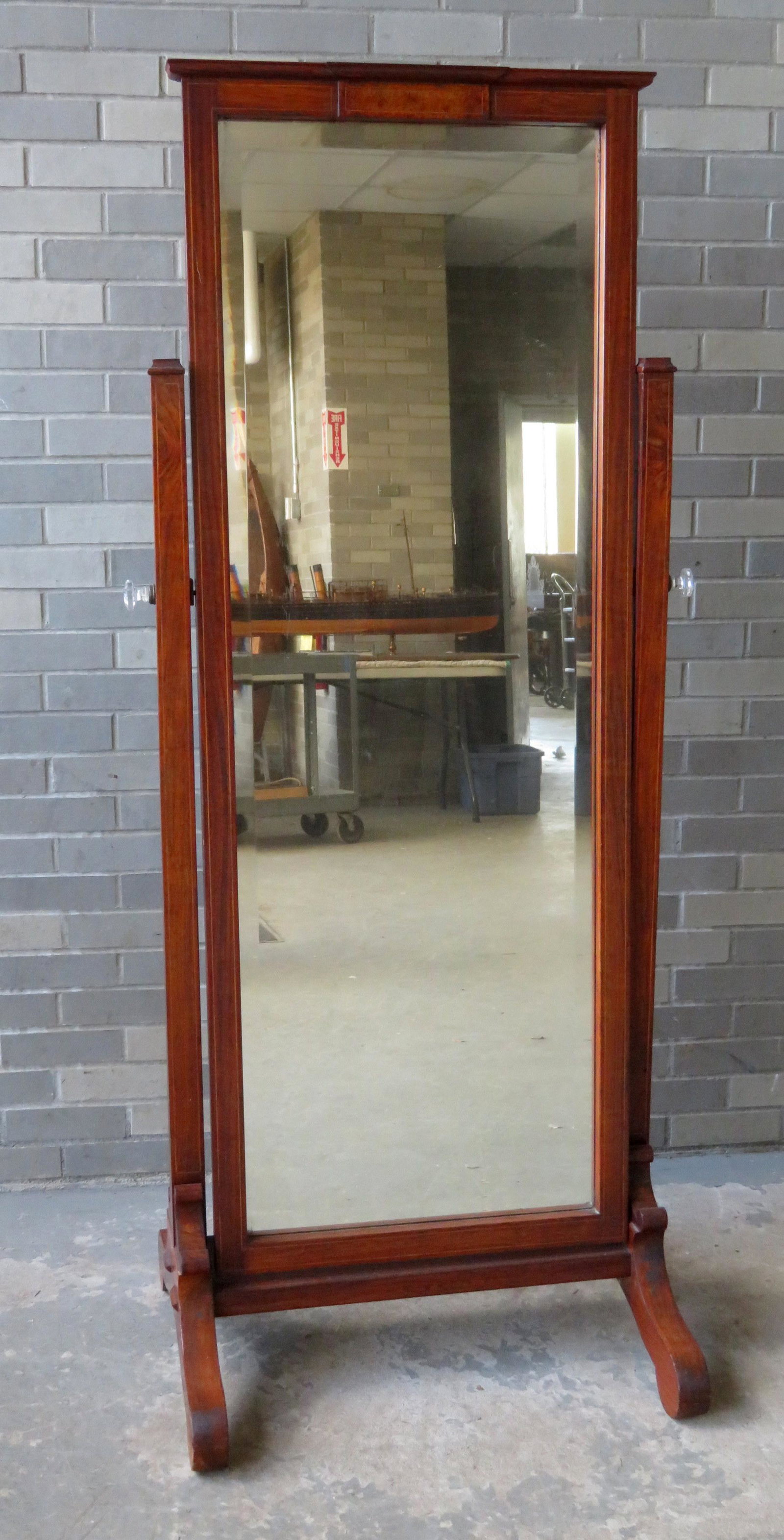Edwardian mahogany chevelle mirror on trestle stand,: Edwardian mahogany chevelle mirror on trestle stand, having a beveled glass mirror, line inlay, scrolled feet, and multi-faceted glass frame holders on each side. Missing finials otherwise good condit