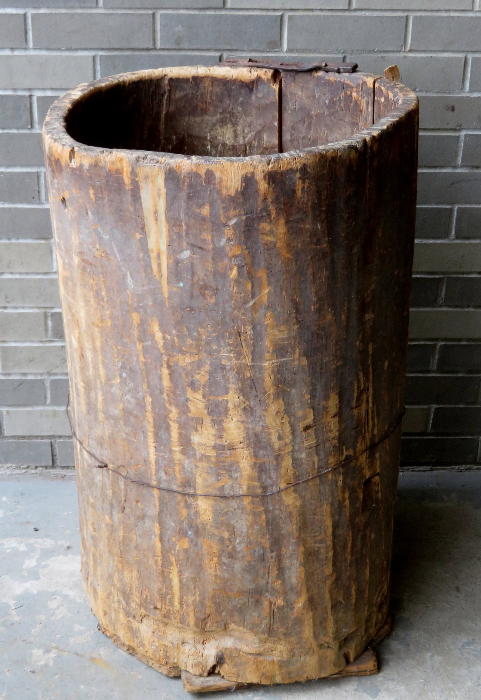 A very primitive 17th/18th century hand dug tree trunk: A very primitive 17th/18th century hand dug tree trunk barrel with applied bottom boards. Several old repairs, some losses, overall fair condition. Approximately 23"D x 34"H.