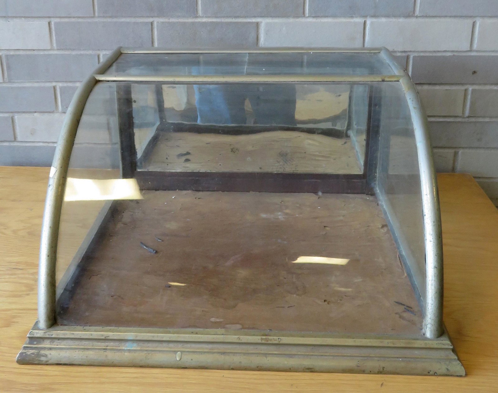 Small table top candy or cigar showcase with curved: Small table top candy or cigar showcase with curved glass front, nickel plated frame, and pull-down rear door with mirror back. 21"W x 20 1/2"D x 11"H. Condition: Top glass in 2 pieces likely an old r