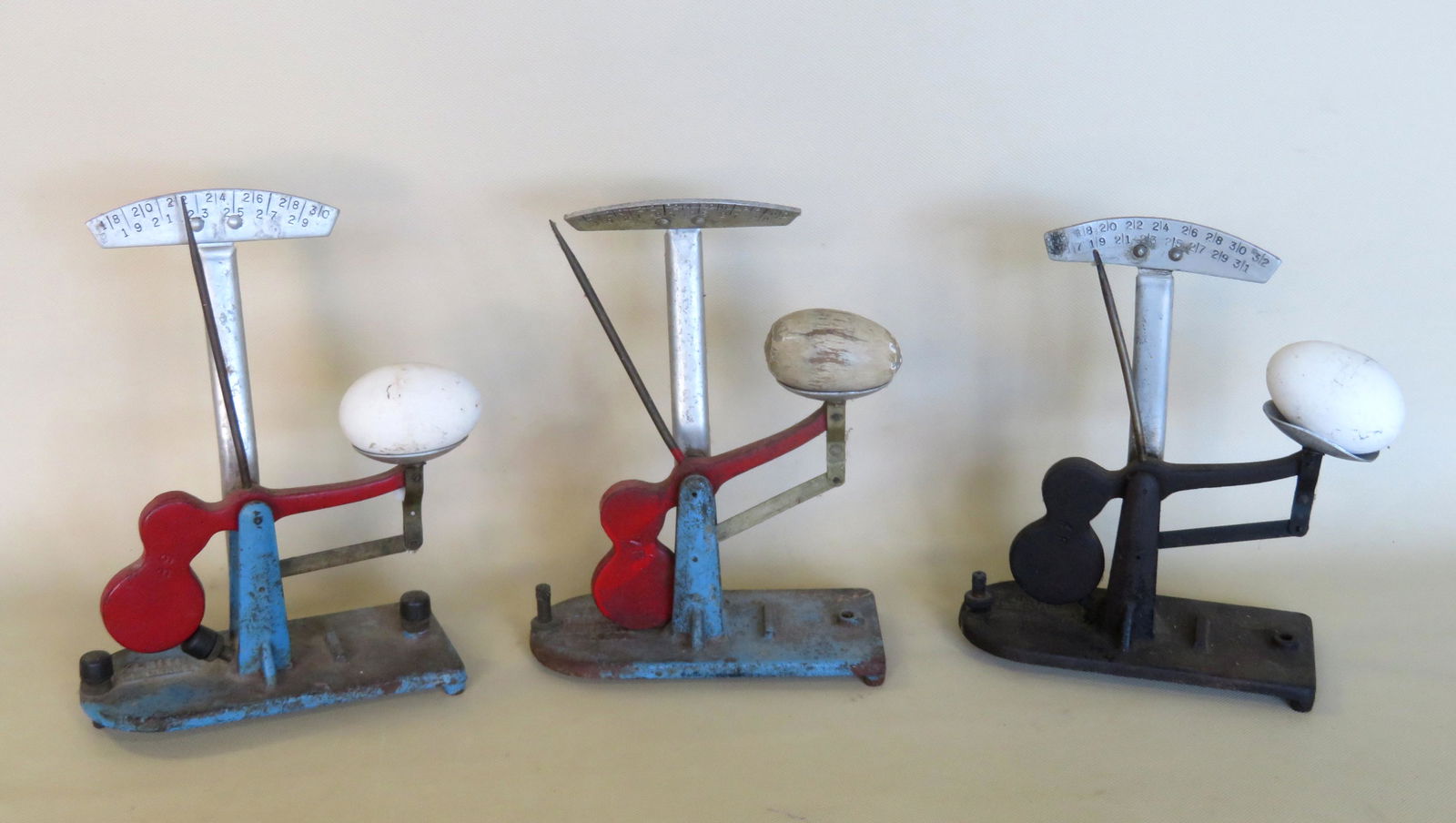 Three cast iron egg scales signed "Zenith Egg Grader" -: Three cast iron egg scales signed "Zenith Egg Grader" - 2 in original blue and red paint, and the other in black paint. Sold with 3 wooden eggs (probably darning eggs). All in good working condition.