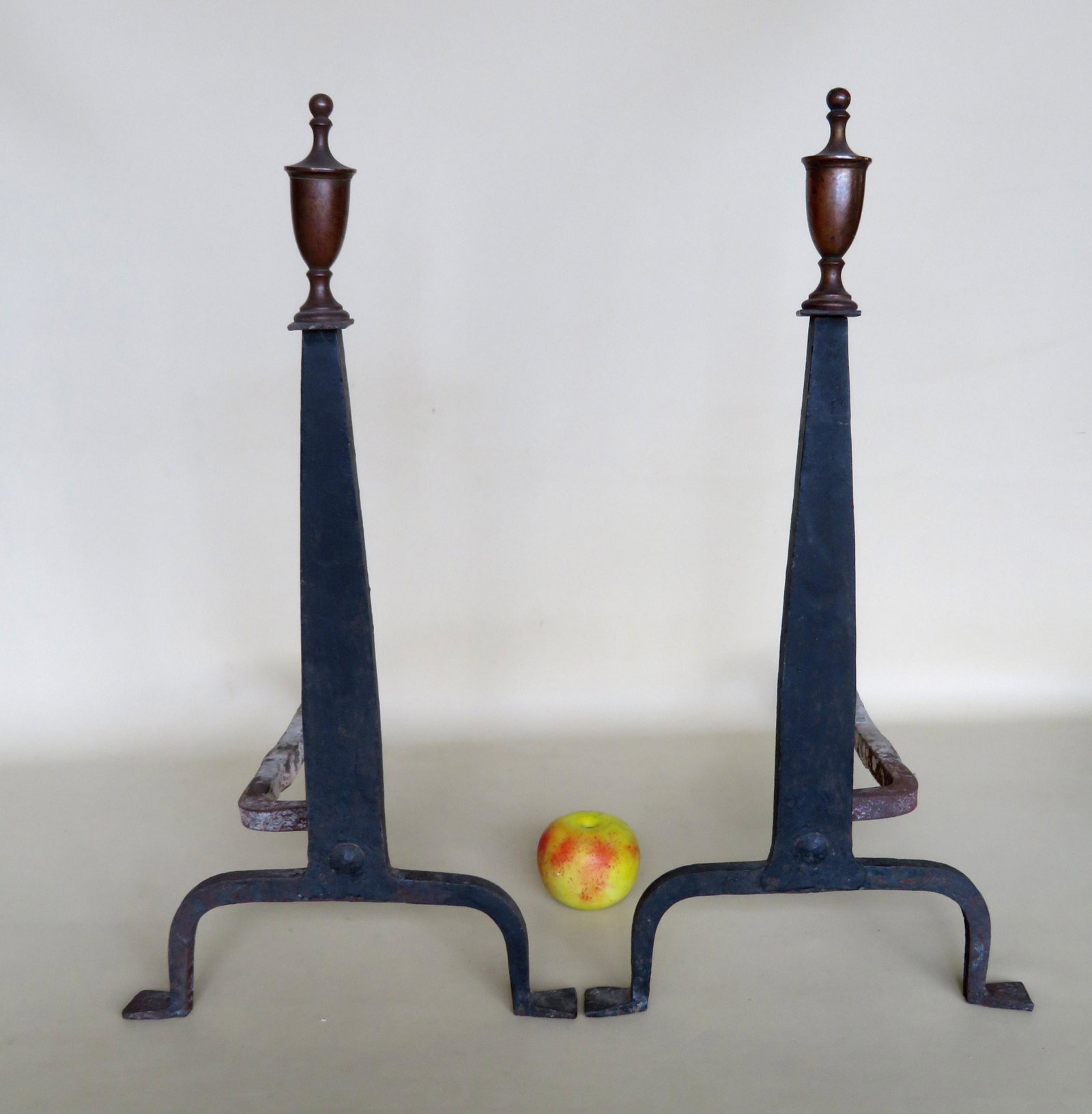 Pair of cast iron Queen Ann style andirons with brass: Pair of cast iron Queen Ann style andirons with brass urn shaped finials, late 19th century. 24"H x 18 1/2"D.