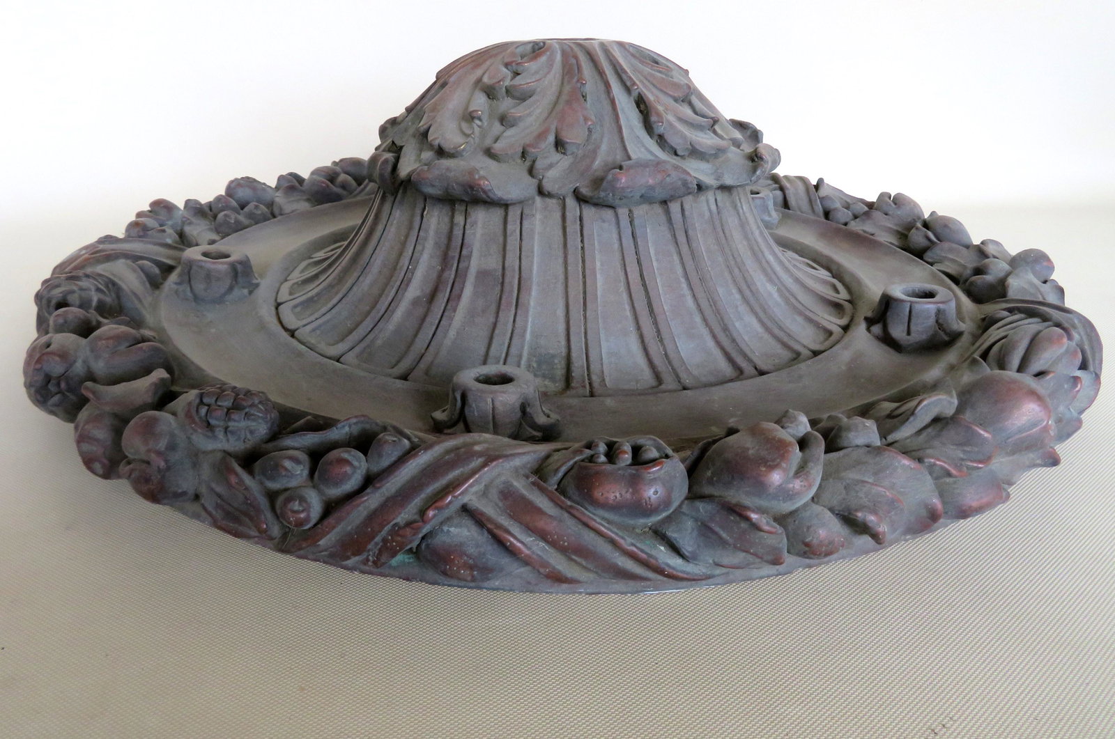 A sculptured terra cotta dome shaped ceiling fixture: A sculptured terra cotta dome shaped ceiling fixture decorated with fruit, and vegetables - the center with acanthus decoration (one leaf with repair, hardly noticeable). Original bronze finish, late 