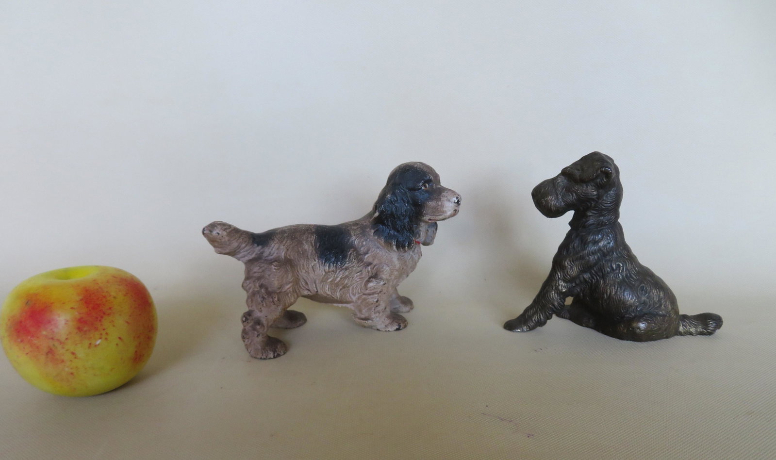 Two small solid cast iron dog door stops including a: Two small solid cast iron dog door stops including a standing spaniel in original black and white paint - 6 3/4"L x 4 3/8"H; and a seated fox terrier in original bronze finish - 5 3/4"L x 4 5/8"H. Bot