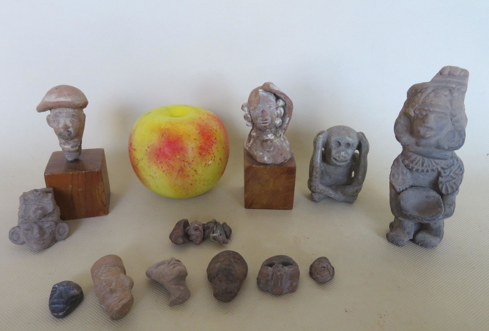 Grouping of miniature carved sculptured heads & masks,: Grouping of miniature carved sculptured heads & masks, a stone carved figure holding a bowl (loss to head piece), and a carved stone monkey hanging ornament (string holes on back side) - very good con