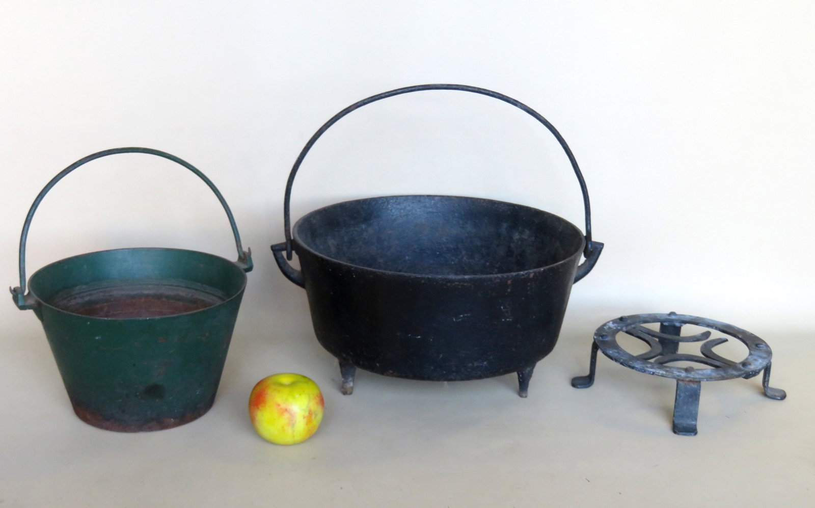 Grouping of 3 country items including an iron footed: Grouping of 3 country items including an iron footed trivet, a small cast iron bucket with bale handle in old green paint probably original, and a larger cast iron footed bucket with bale handle (tiny