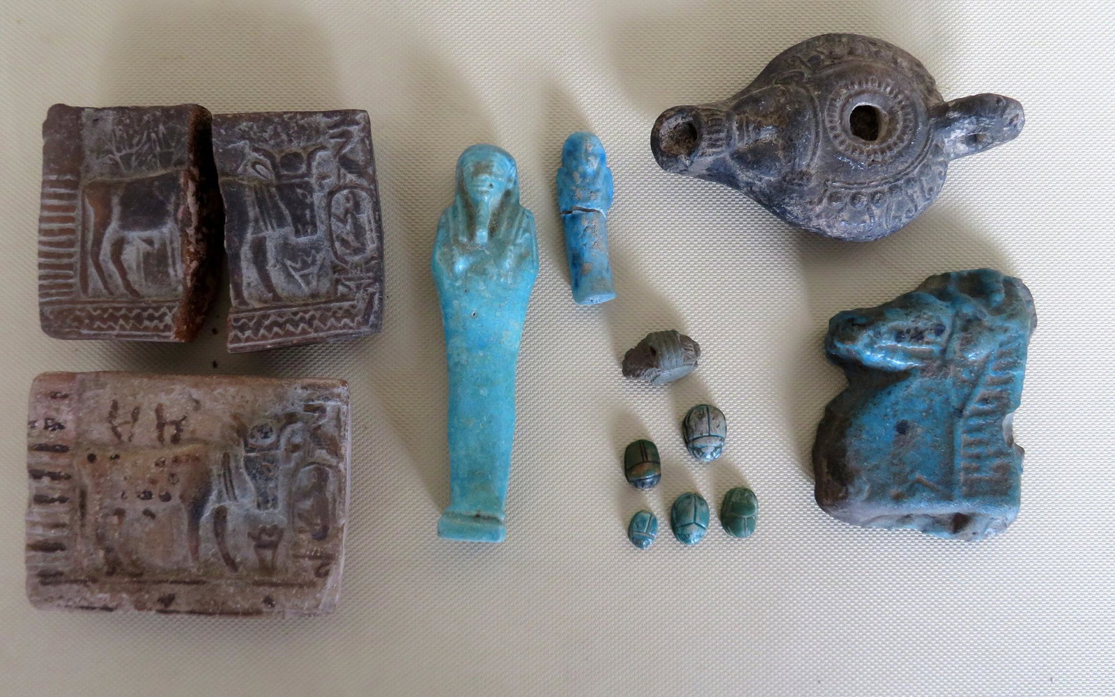 Grouping of mostly Egyptian stone artifacts believed to: Grouping of mostly Egyptian stone artifacts believed to be ancient including: A small blue plaque with relief carved horse head - 3 1/4" x 2 1/2", 2 stone plaques decorated in relief with bull and bir