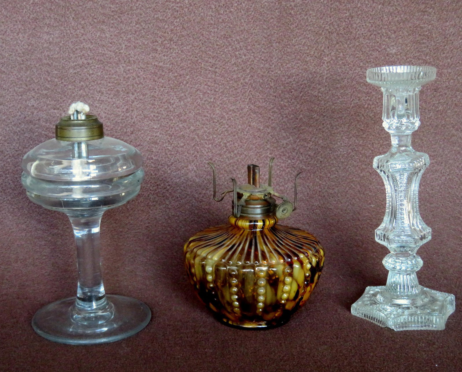 Three early glass lighting devices, 18th/19th century: Three early glass lighting devices, 18th/19th century including: 1) Hand blown colorless fluid lamp, very good condition - 7"H; 2 fancy colorless candlesticks with irregular wafer separating column fr