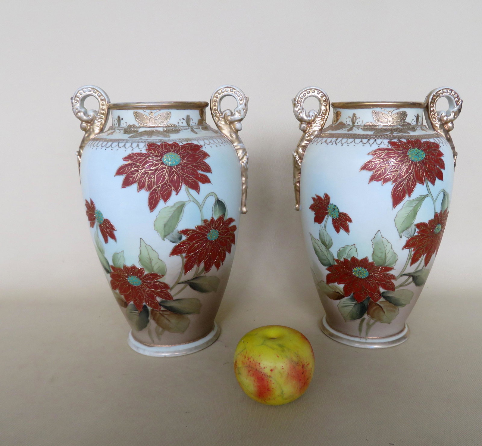 Matched pair of porcelain vases decorated with flowers: Matched pair of porcelain vases decorated with flowers and having doubled scrolled handles, marked Nippon with blue coloring on base - 12"H x 8"W. Both in very good condition. No damage, both in very 