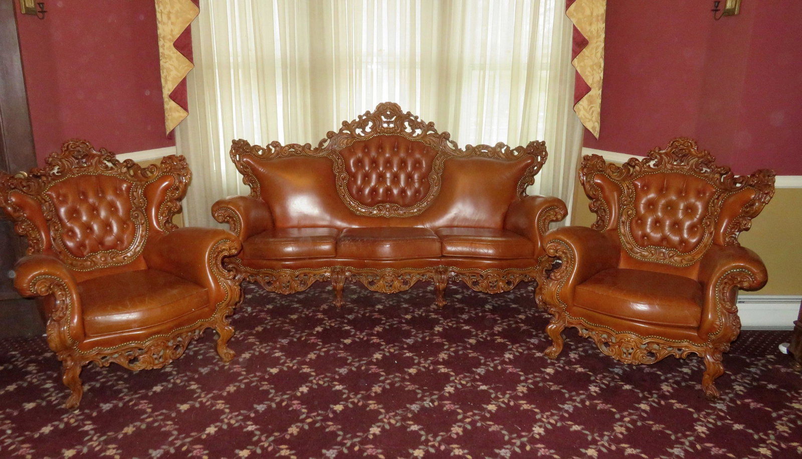 A Victorian 3 piece parlor set with leather seats,: A Victorian 3 piece parlor set with leather seats, consisting of a couch and 2 matching chairs. Note the extensive and fancy carved wooden frames. Found in a Quebec city hotel, circa 1950-70. All with