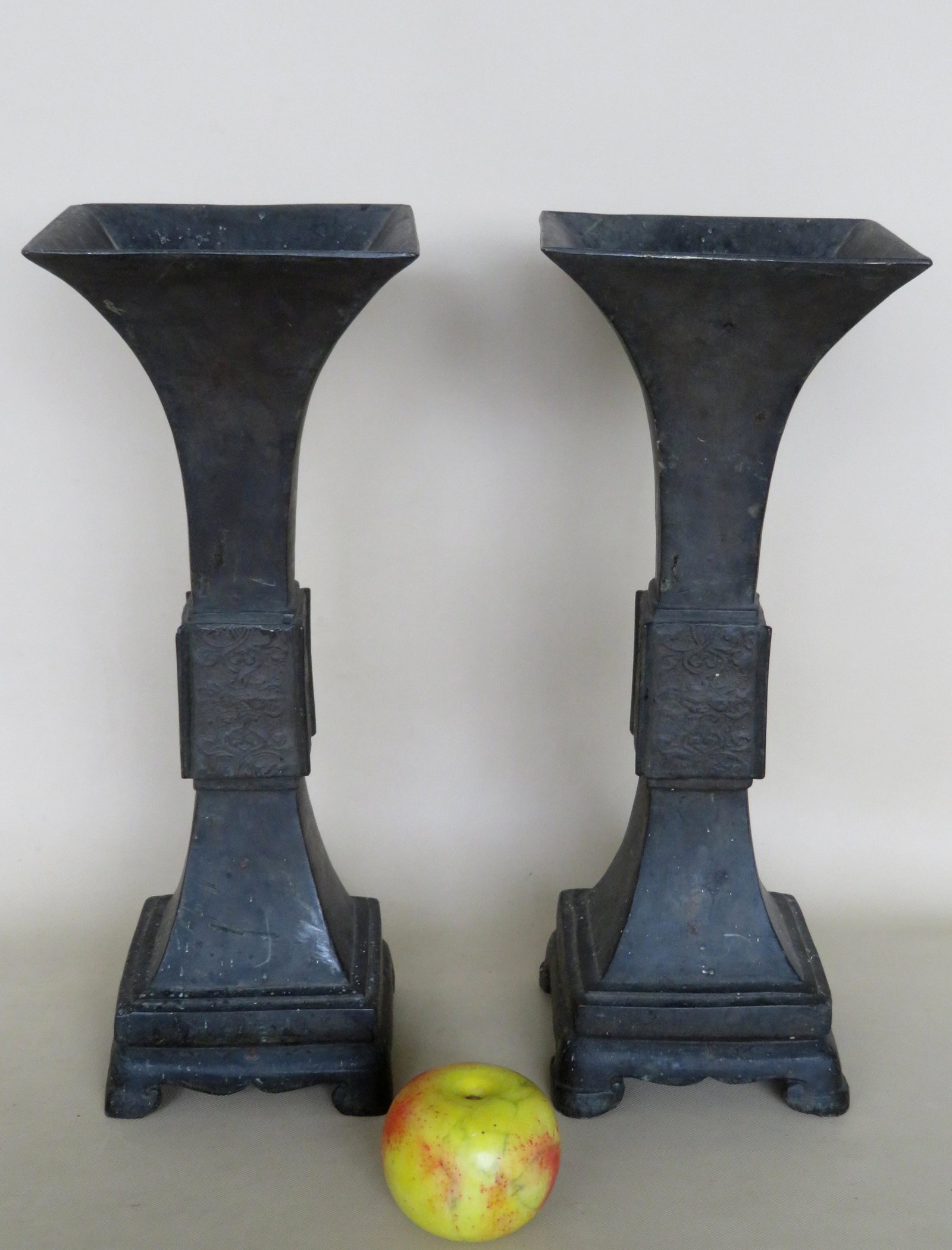 Two oriental bronze lamps, trumpet shaped with square: Two oriental bronze lamps, trumpet shaped with square top (6 1/2" x 6 1/2"). Overall height 16 1/2". The center of the vase with rectangular shaped panels decorated with scrolls on all sides. Conditio