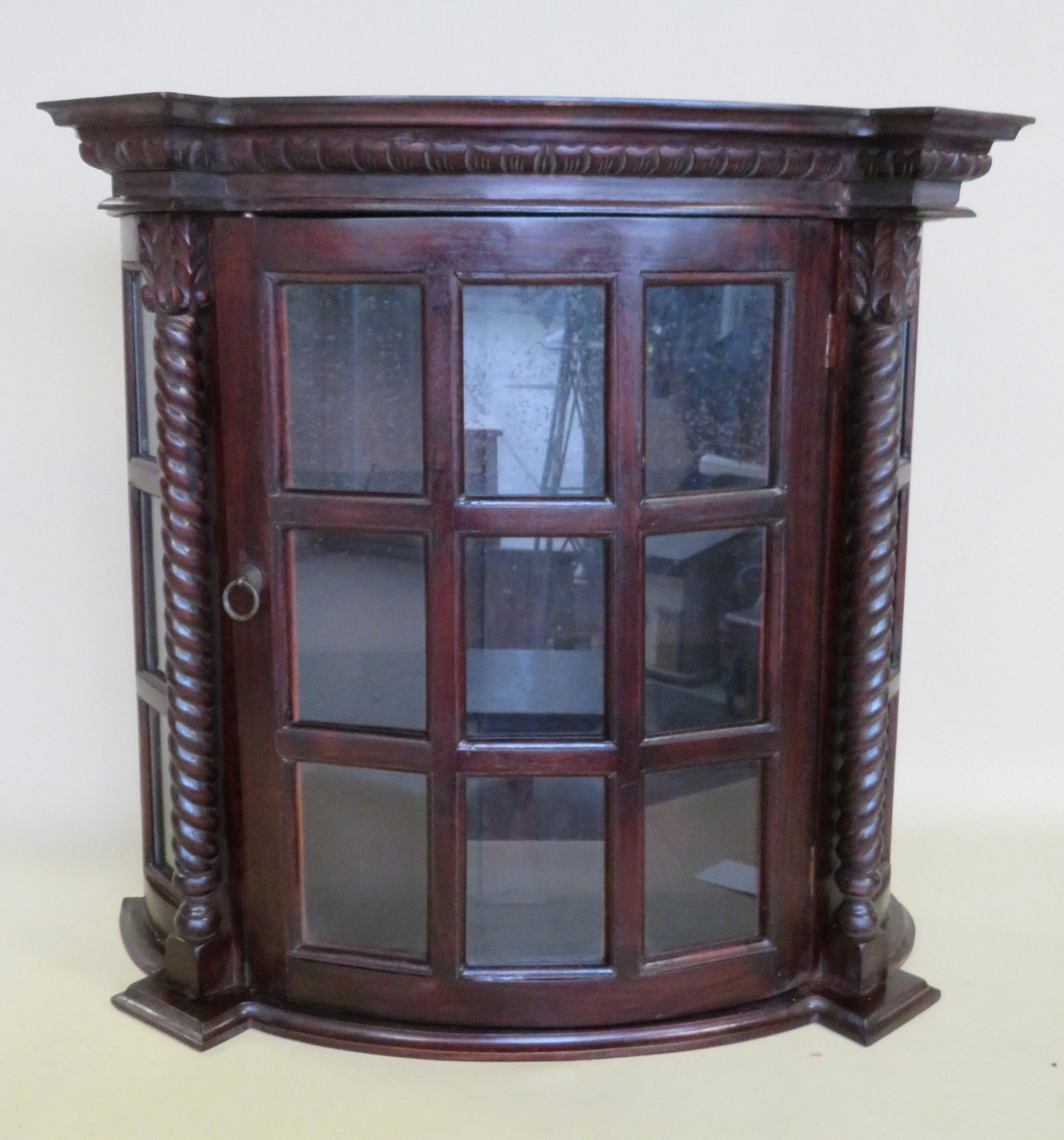 Mahogany 1 door wall cabinet with bow front and having: Mahogany 1 door wall cabinet with bow front and having 9 lights - twisted columns on each side of door. 20th century. 27 3/4"W x 10"D x 27"H. Good condition.