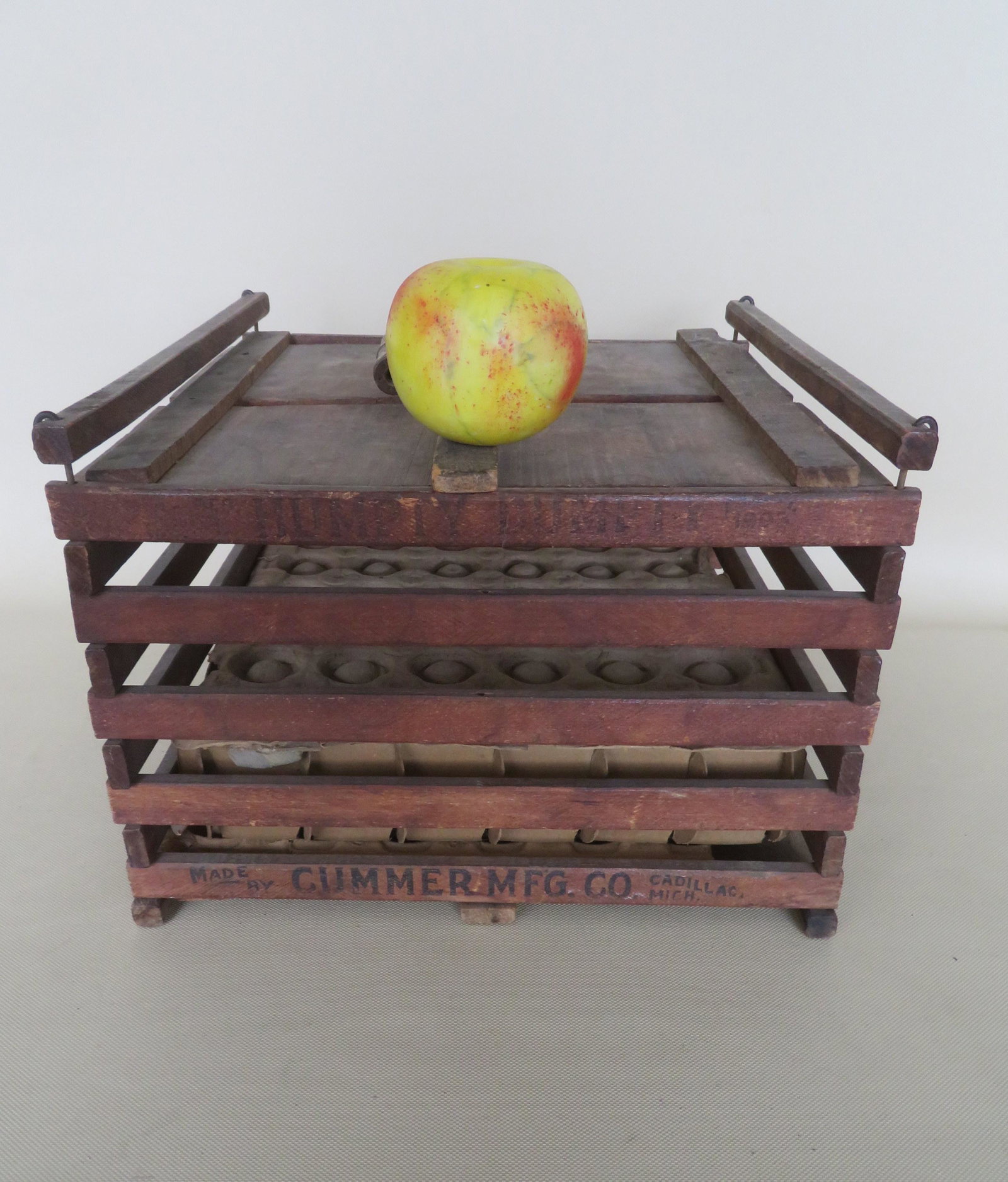 Wooden egg crated with bale handle signed "Made by: Wooden egg crated with bale handle signed "Made by Cummer Mfg. Co. Cadillac, Mich. - 13"W x 13"D x 9 1/2"H. Very good condition.