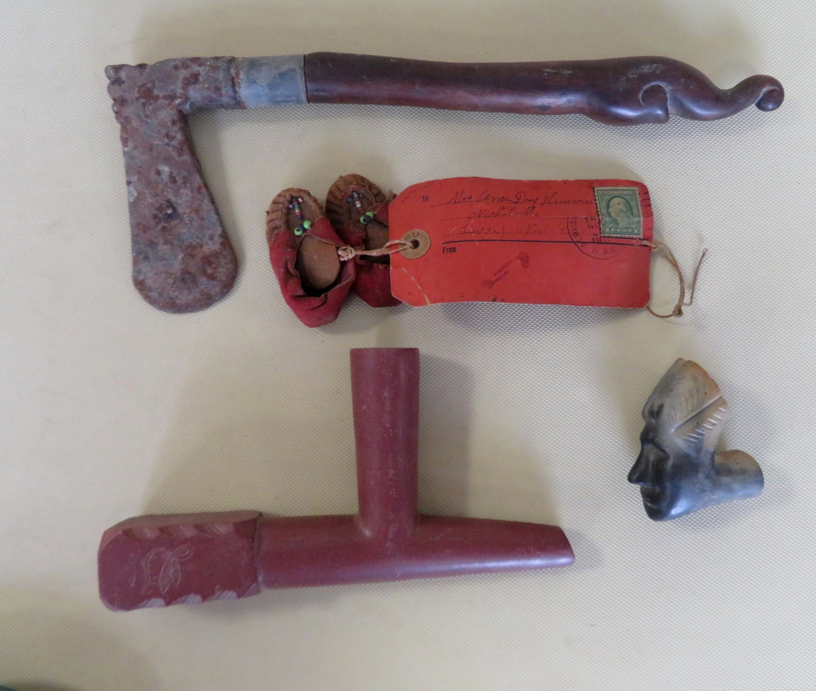 Grouping of 4 ethnographic collectibles including a: Grouping of 4 ethnographic collectibles including a Native American catlinite pipe with engraved Indian head on side of bowl, probably trading post item; an earthenware figural Indian pipe bowl; iron 