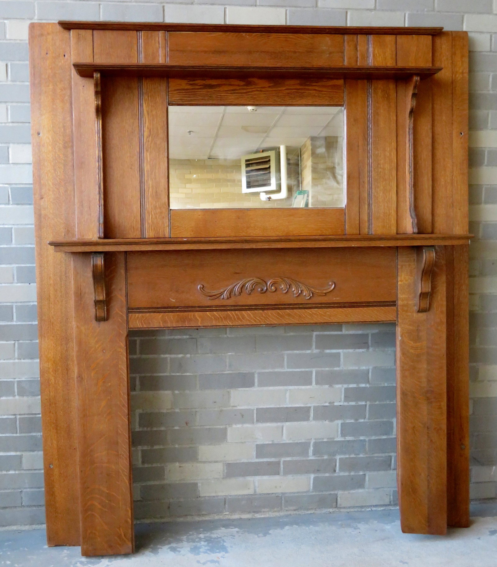 Golden oak fireplace mantle with mirror back and: Golden oak fireplace mantle with mirror back and attached shelf - applied scroll shaped molding under middle shelf. Overall size 59 3/4"W x 70"H - opening 35 1/2"W x 29 1/2"H.