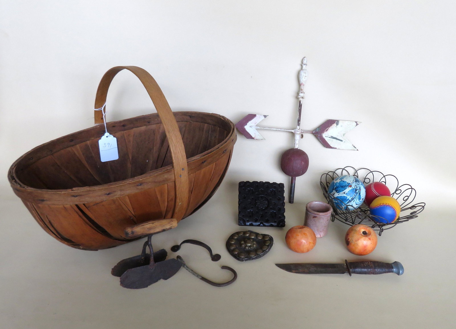 Grouping country items including melon basket wired: Grouping country items including melon basket wired plate, arrow weathervane, wall paper stamp, 2 stone fruit, marbleized hand painted wooden ball in blue and white, etc.