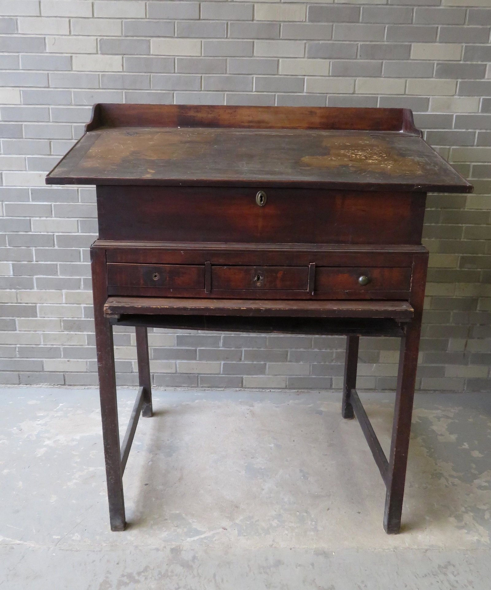Early primitive desk on frame for station master,: Early primitive desk on frame for station master, having a lift top with interior cubby holes and 3 drawers, dovetailed frame, dovetailed gallery, 3 exterior drawers over pullout writing surface over 