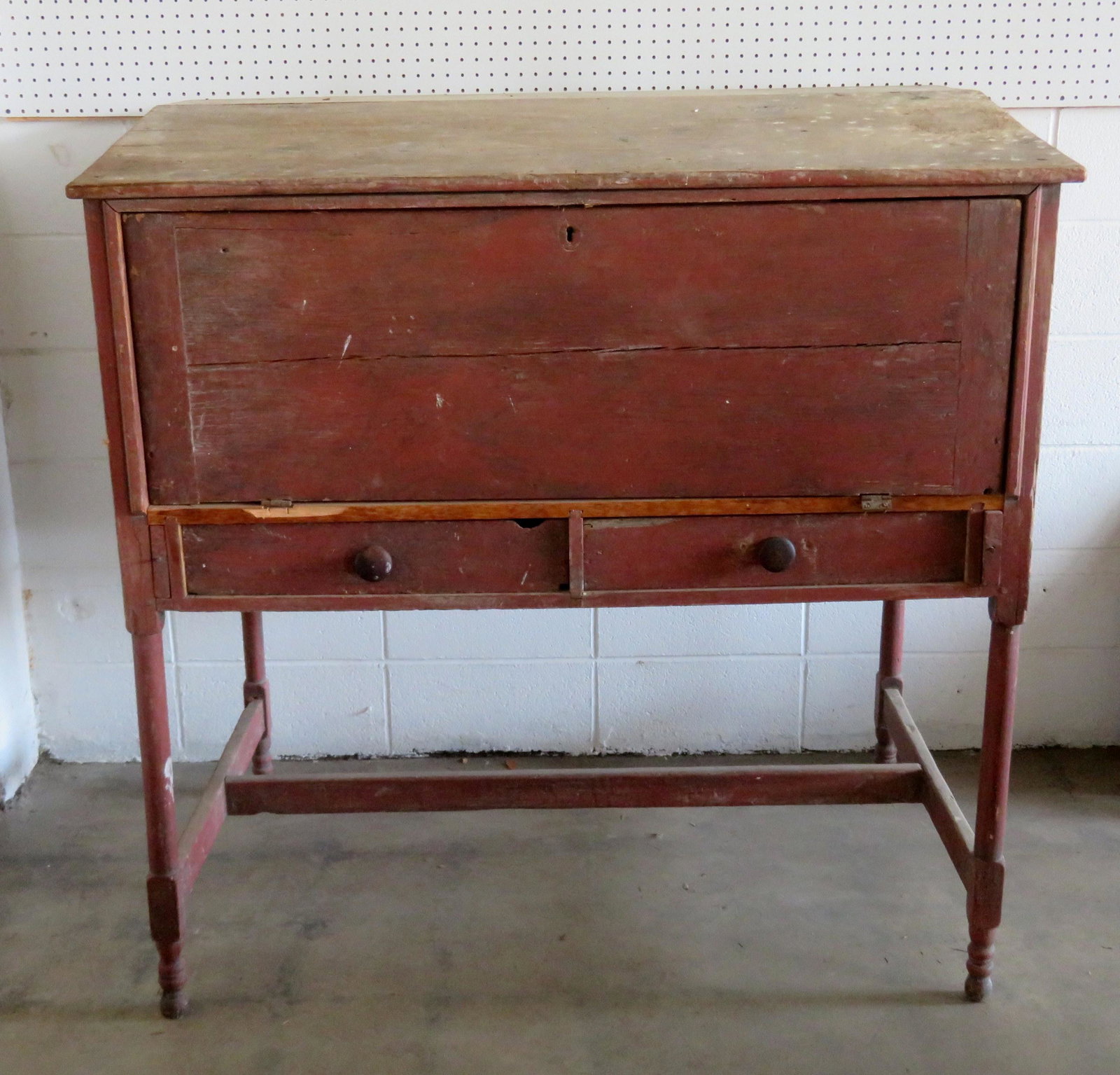 Large station masters desk with slanted writing surface: Large station masters desk with slanted writing surface top, cubby hole interior, drop front, cross stretchers, and 2 short drawers. Original red stain. Condition: Barn found with staining on top, mou