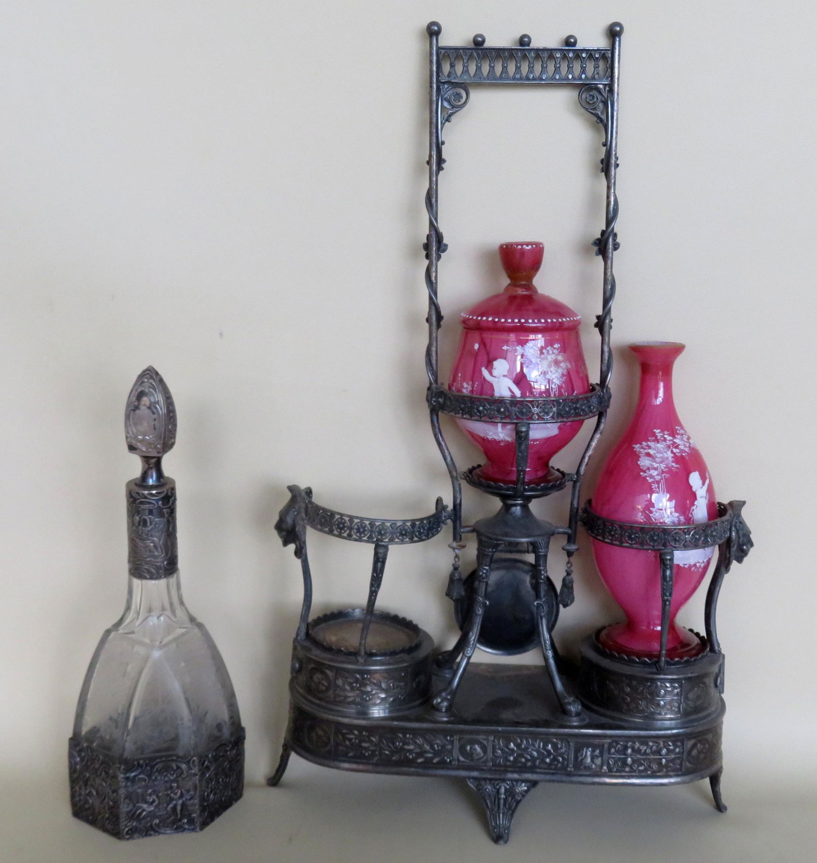 Small grouping of decorative objects including: An: Small grouping of decorative objects including: An Aesthetic Movement silver decanter set, incomplete, and an early etched wine bottle with applied silver ornamentation. The silver plate decanter has